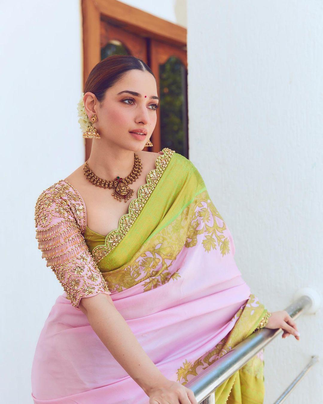 In hues of pink with verdant borders and intricate golden zari work, Tamannaah transformed into a vision. The pink saree gracefully flowed, reflecting her grace and poise. 